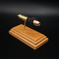 High angled view of a .50 Action Express Hornady Custom 300gr XTP cartridge anatomy display highlighting the projectile, simulated powder, cartridge case, primer cup, and anvil on a cherry wood base.