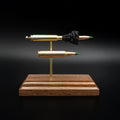 Front view of a 5.56x45 NATO SS109 Green Tip Comparison Series display featuring an exploded cartridge with exposed simulated powder displayed above a complete live cartridge on a handcrafted walnut wood base.