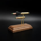Left side profile of a 5.56x45 NATO SS109 Green Tip Comparison Series display featuring an exploded cartridge with simulated powder above a complete live cartridge on a walnut presentation base.