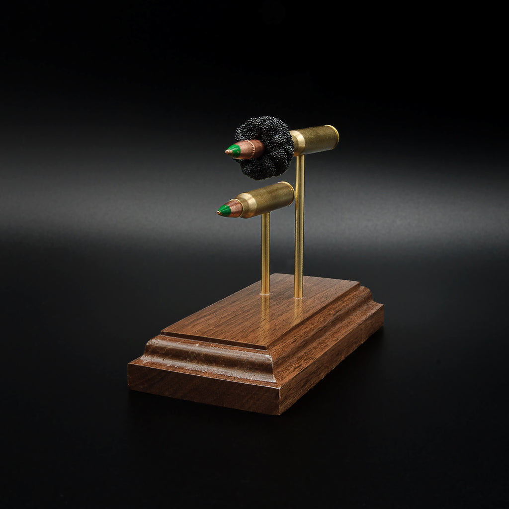 Right side profile of an inert 5.56x45 NATO SS109 Green Tip Comparison Series highlighting the expanded cartridge components, complete cartridge, brass cases, and handcrafted walnut base.