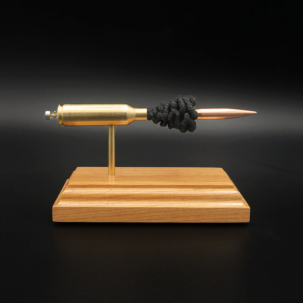 Front view of a 6.5 PRC Berger 153.5gr Long Range Hybrid Target cartridge anatomy display showing the primer cup, anvil, Lapua cartridge case, simulated powder, and projectile on a hardwood base.