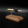 Front three-quarter view of a handcrafted 6.5 PRC exploded cartridge display featuring a Hornady 147gr ELD-M Match bullet with simulated powder on a walnut wood base.