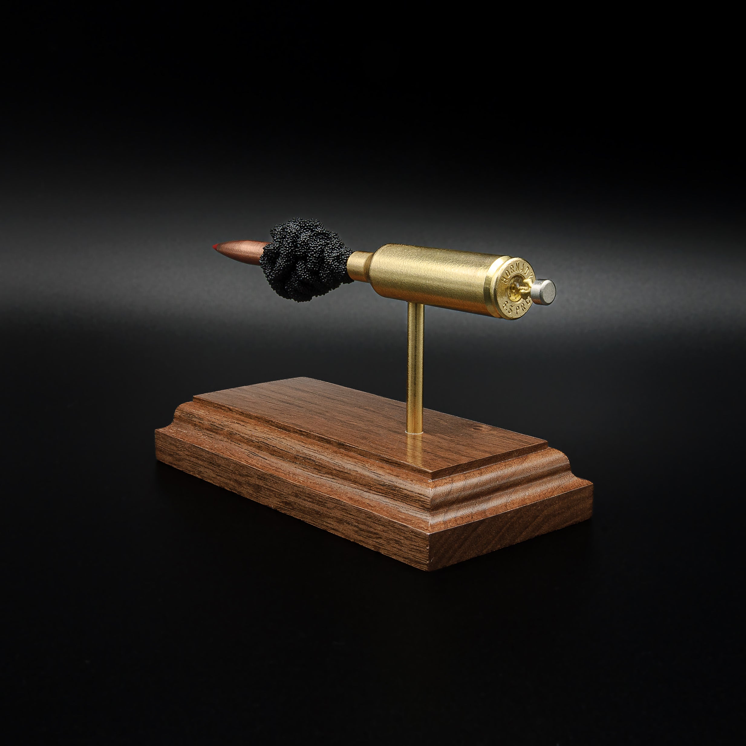 Opposite rear angle of a 6.5 PRC anatomy cartridge display featuring the Hornady 147gr ELD-M Match projectile, exposed powder column, and walnut wood base.