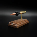 Front-right perspective of a handcrafted 6.5 PRC exploded ammunition display highlighting the Hornady 147gr ELD-M Match bullet, brass case, exposed simulated powder, and walnut display base.