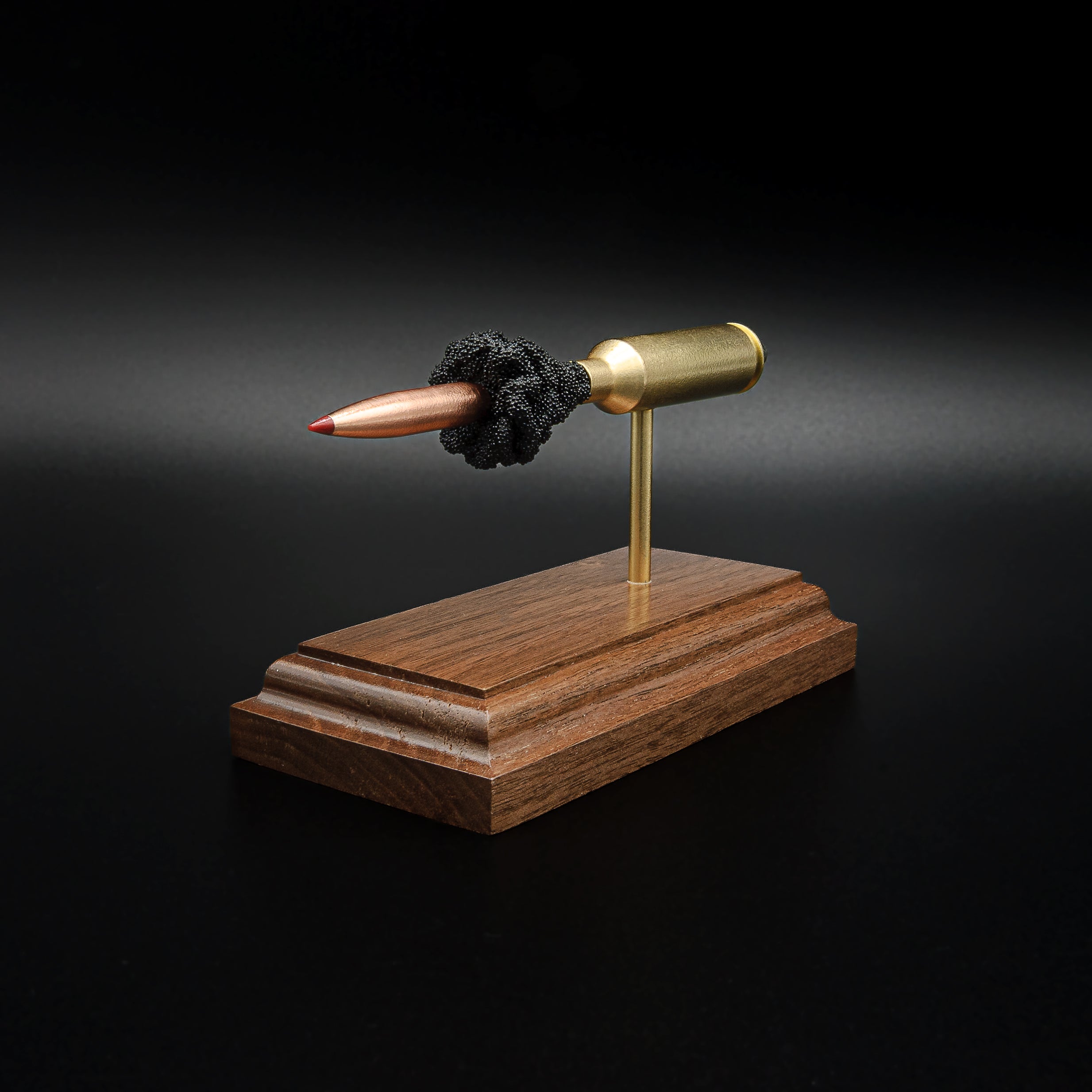 Front-right perspective of a handcrafted 6.5 PRC exploded ammunition display highlighting the Hornady 147gr ELD-M Match bullet, brass case, exposed simulated powder, and walnut display base.