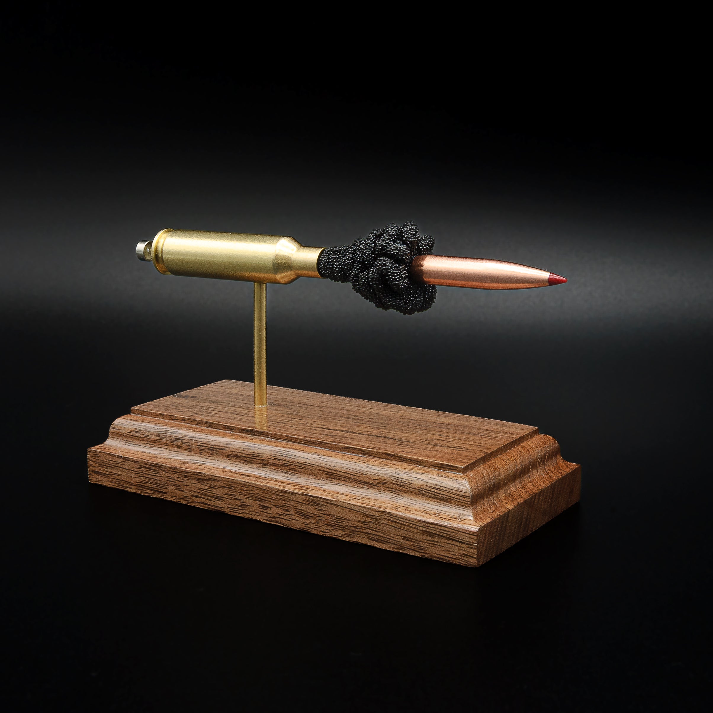 Front profile of a handcrafted 6.5 Creedmoor exploded cartridge display featuring a Hornady 143gr ELD-X bullet with simulated powder on a walnut wood base.