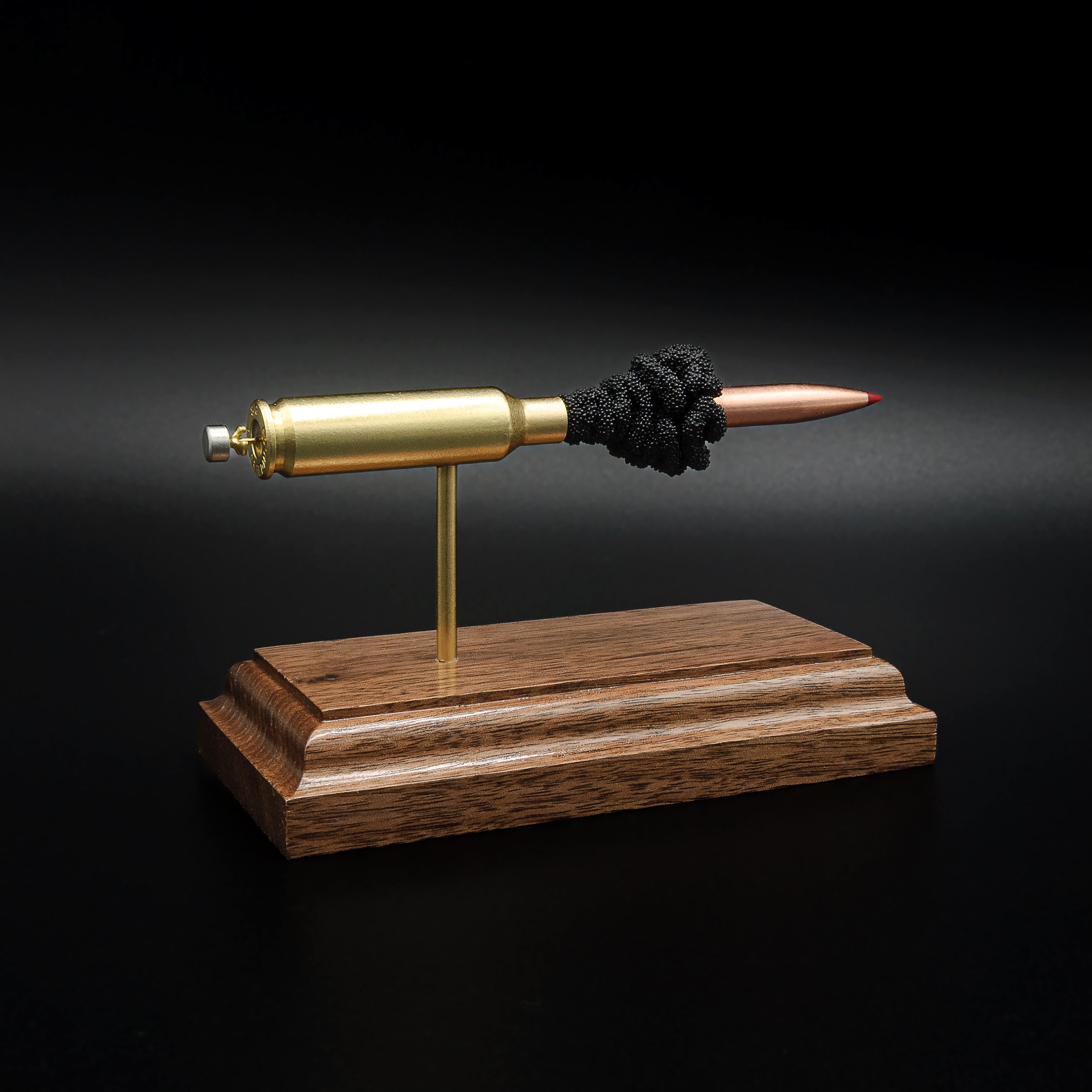 Left-rear perspective of a handcrafted 6.5 Creedmoor cartridge display featuring a Hornady 143gr ELD-X bullet mounted on a solid walnut wood base.