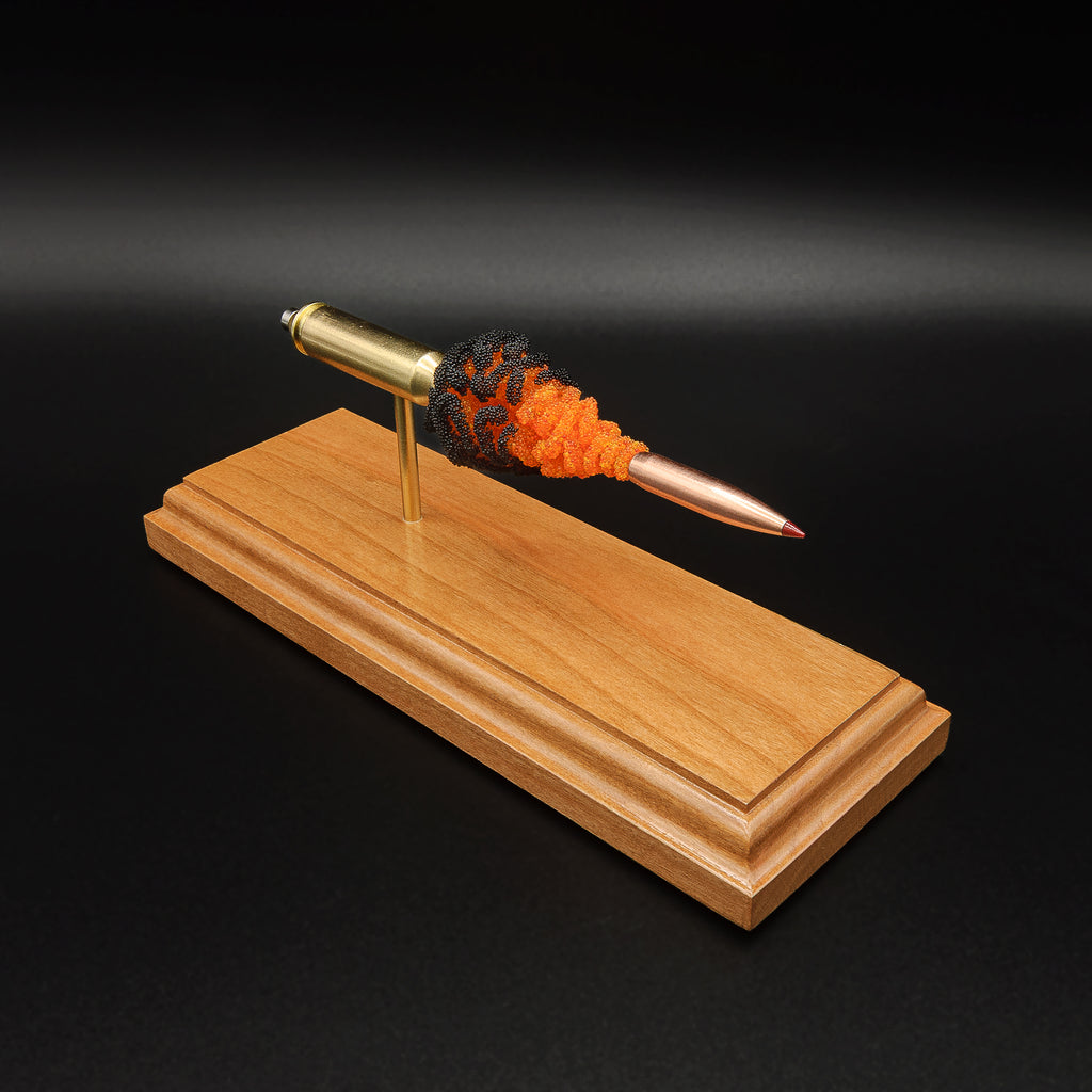 Elevated view of a 6.5 Creedmoor Hornady 143gr ELD-X FirePowder cartridge anatomy display mounted on a solid cherry hardwood base.
