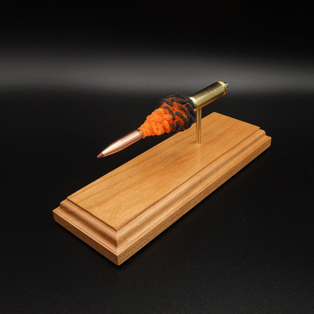 Front angled view of the 6.5 Creedmoor FirePowder display showing the red-tipped Hornady 143gr ELD-X, simulated powder expansion, Alpha brass case, primer cup, and anvil.