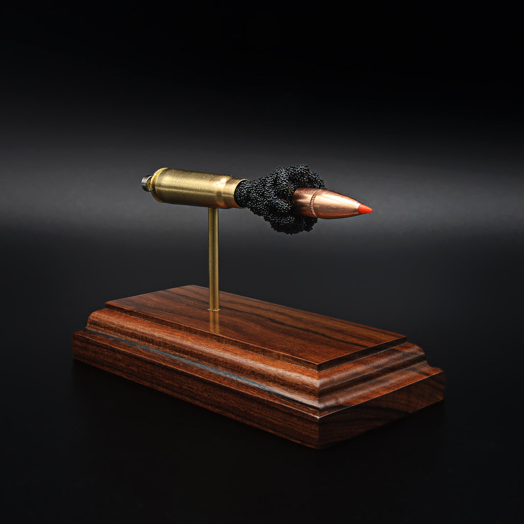 A 7.62x39 cartridge model displayed on a rosewood base, with each part separated to show the internal construction of the round