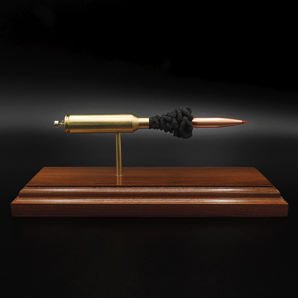 7mm PRC Hornady 180gr ELD-M expanded cartridge display on Bolivian Rosewood base showing visible primer cup, anvil, cartridge case, simulated powder, and projectile in left side profile.