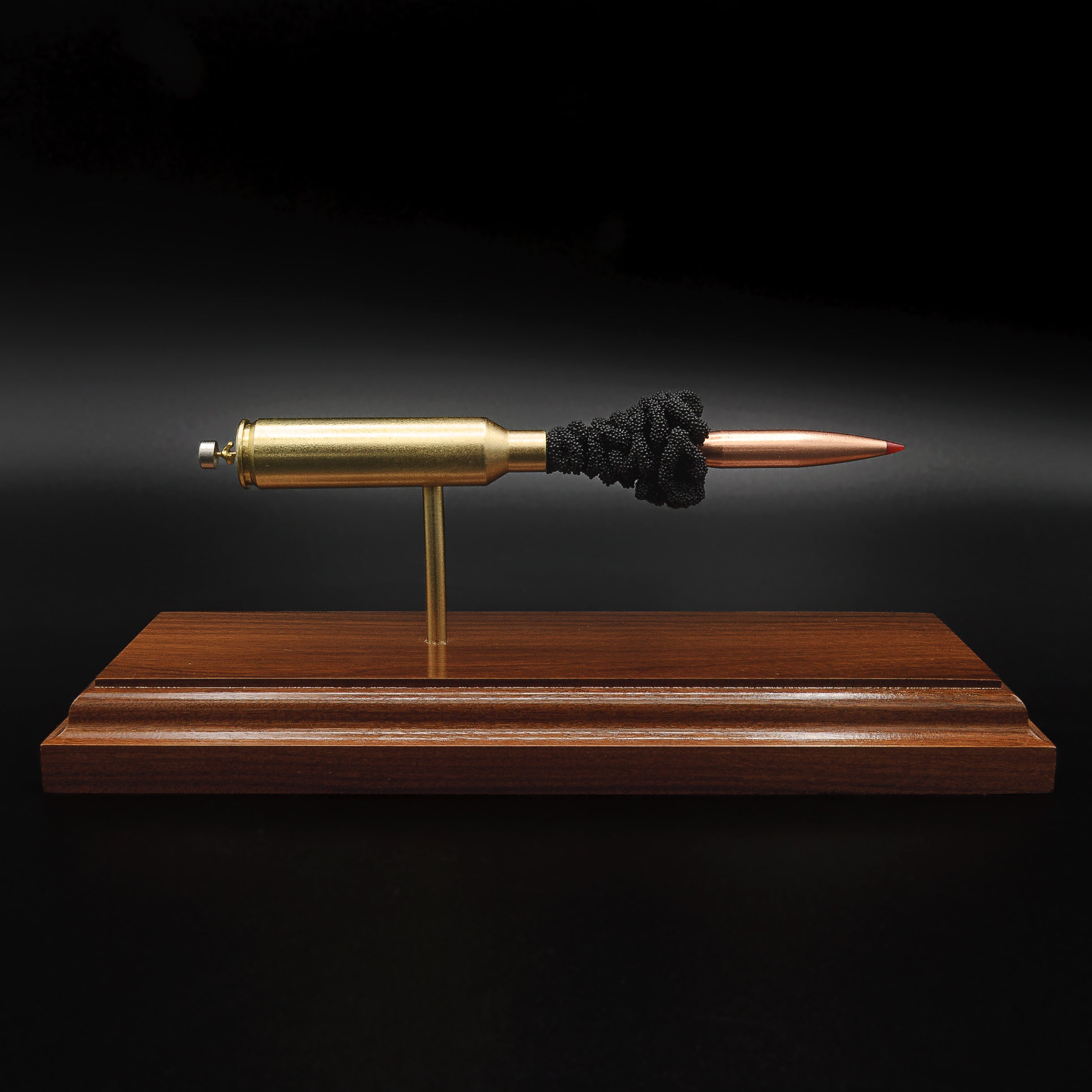 7mm PRC Hornady 180gr ELD-M expanded cartridge display on Bolivian Rosewood base showing visible primer cup, anvil, cartridge case, simulated powder, and projectile in left side profile.