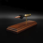 Rear three-quarter view of a 7mm PRC Hornady 180gr ELD-M expanded cartridge display on a Bolivian Rosewood base showing the primer cup, anvil, cartridge case, simulated powder, and projectile.
