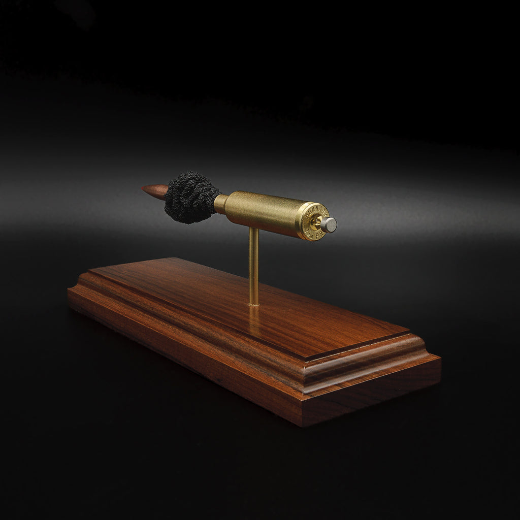 Rear view of a 7mm PRC Hornady 180gr ELD-M expanded cartridge display mounted on a Bolivian Rosewood base with visible primer cup, anvil, cartridge case, simulated powder, and projectile.
