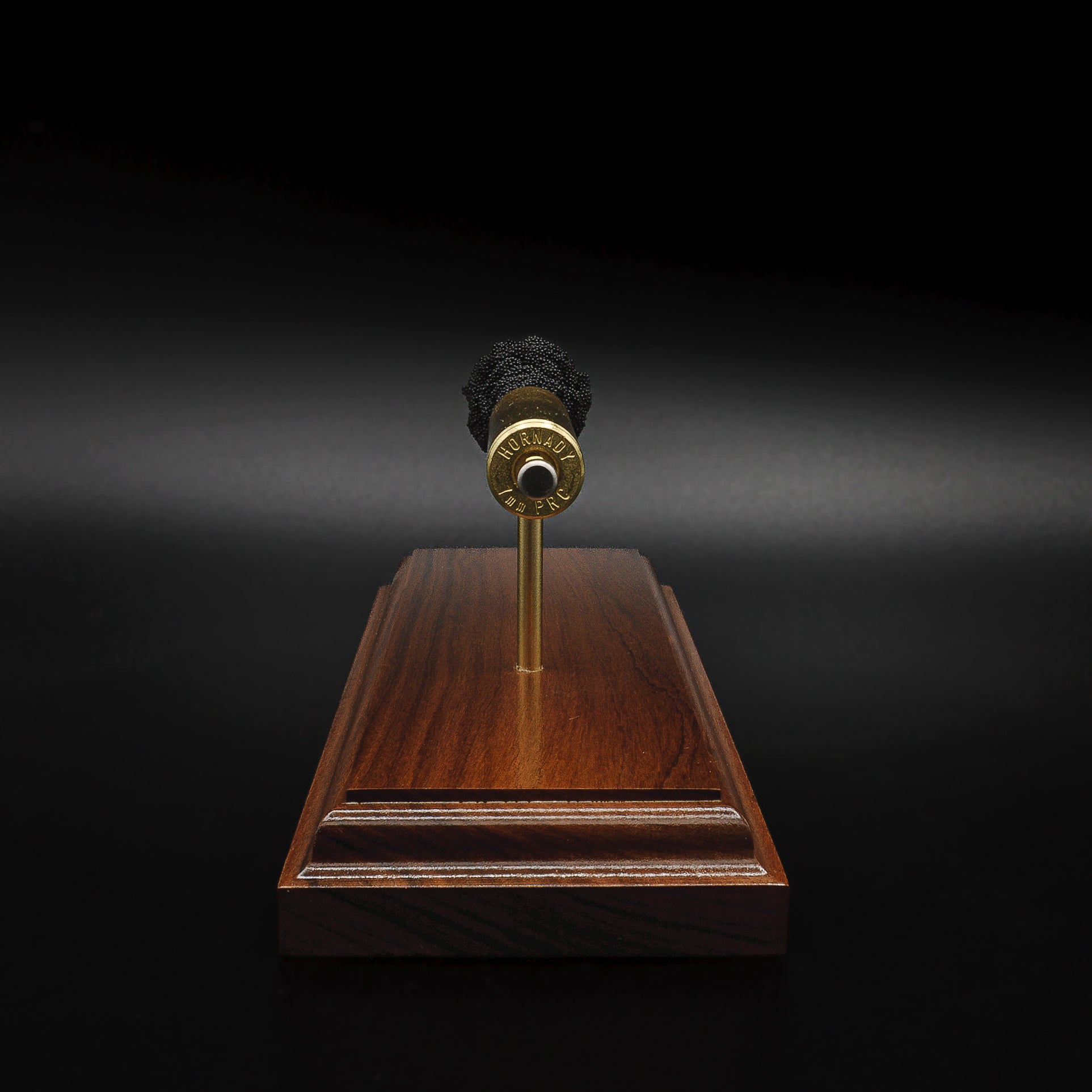 Rear three-quarter view of a 7mm PRC Hornady 180gr ELD-M expanded cartridge display on a Bolivian Rosewood base showing the primer cup, anvil, cartridge case, simulated powder, and projectile.