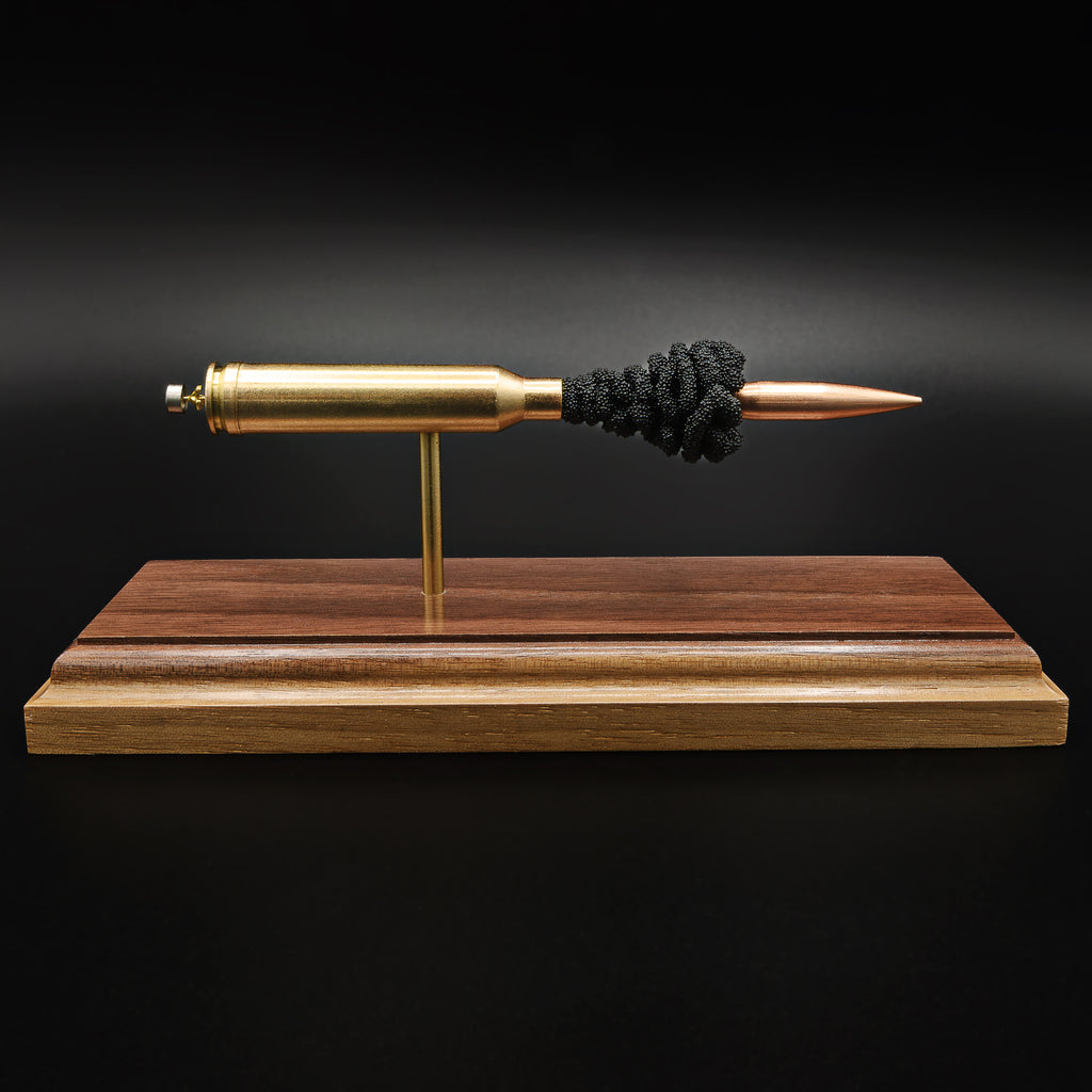 Front view of an exploded 7mm Remington Magnum cartridge display featuring a 168 grain Berger VLD bullet with exposed simulated powder mounted on a handcrafted walnut wood presentation base.
