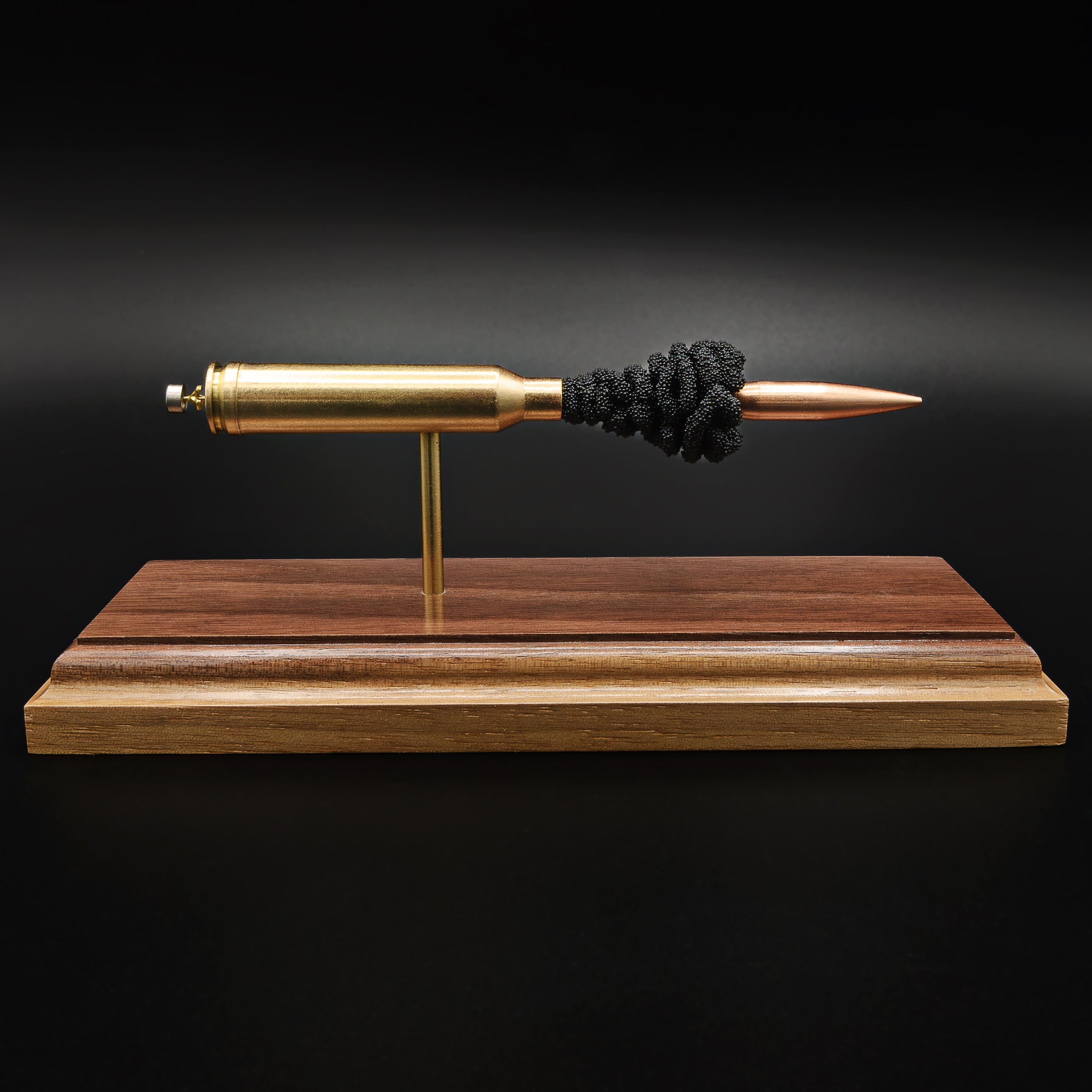 Front view of an exploded 7mm Remington Magnum cartridge display featuring a 168 grain Berger VLD bullet with exposed simulated powder mounted on a handcrafted walnut wood presentation base.