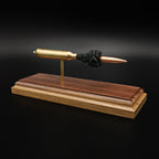 Front-right three-quarter view of a handcrafted 7mm Remington Magnum display showcasing the 168gr Berger VLD bullet, brass case, exposed simulated powder, and walnut wood base.