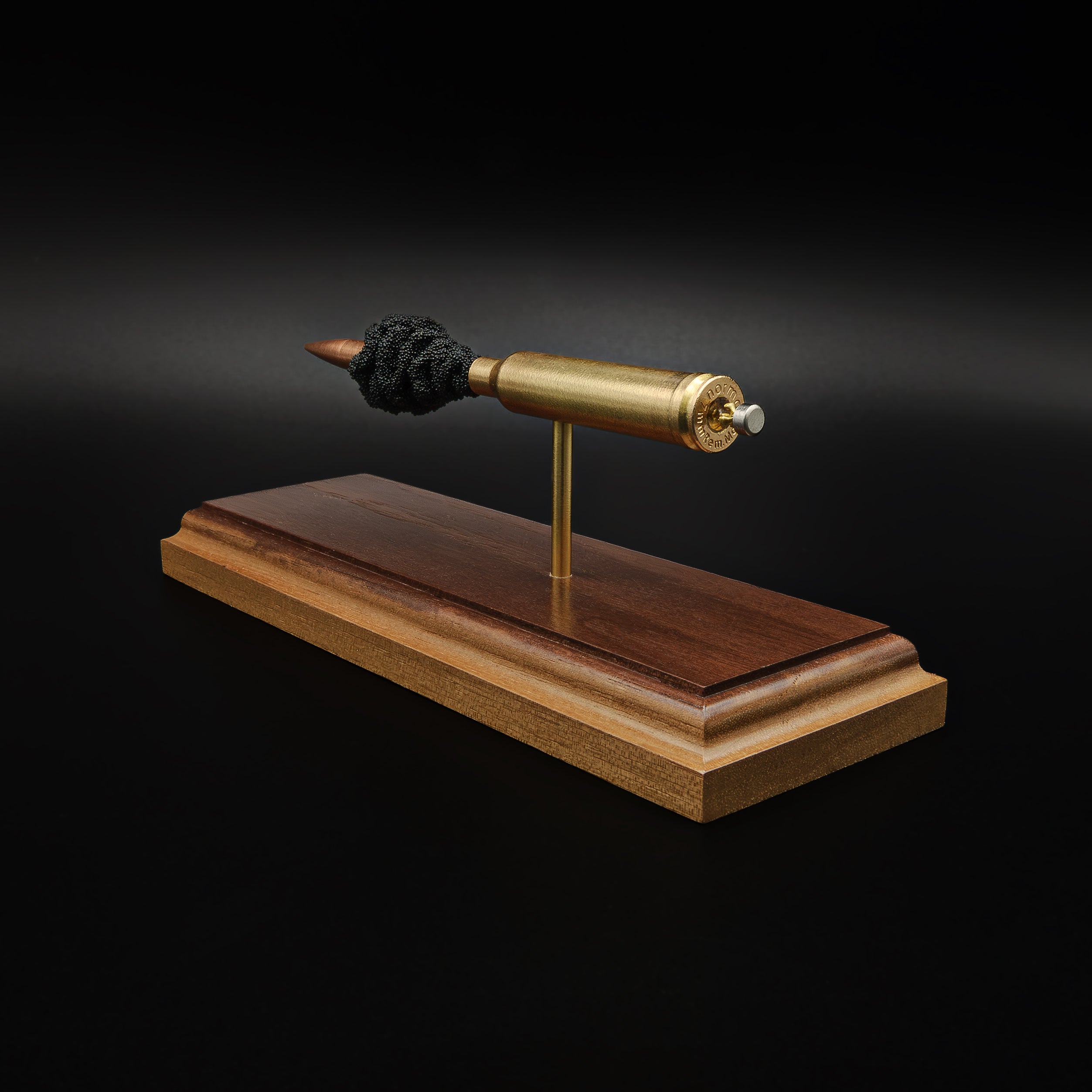 Rear-right perspective of a handcrafted 7mm Remington Magnum exploded cartridge display featuring the 168gr Berger VLD bullet, brass case, exposed simulated powder, and solid walnut wood base.