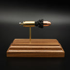 Side profile of 9mm Luger full metal jacket cartridge anatomy model on walnut base