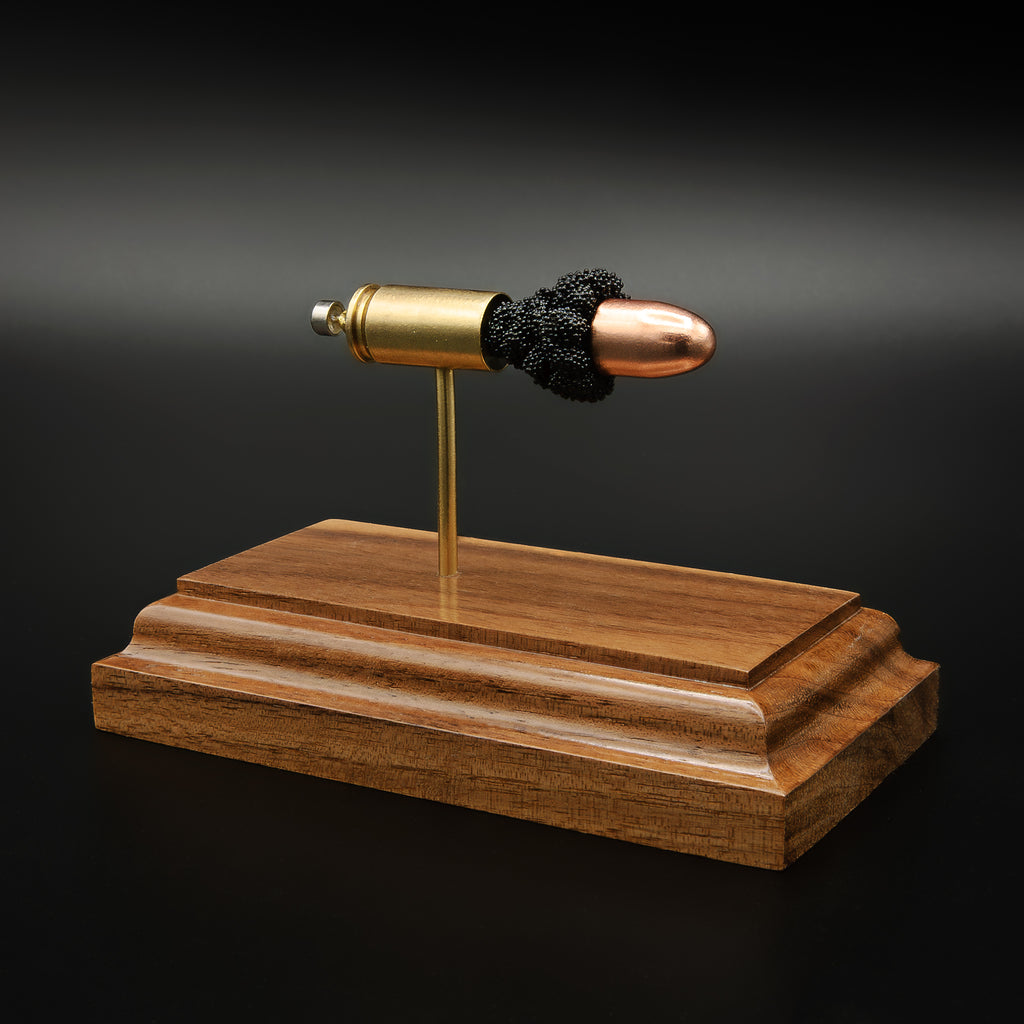 9mm Luger FMJ exploded cartridge anatomy model on walnut base