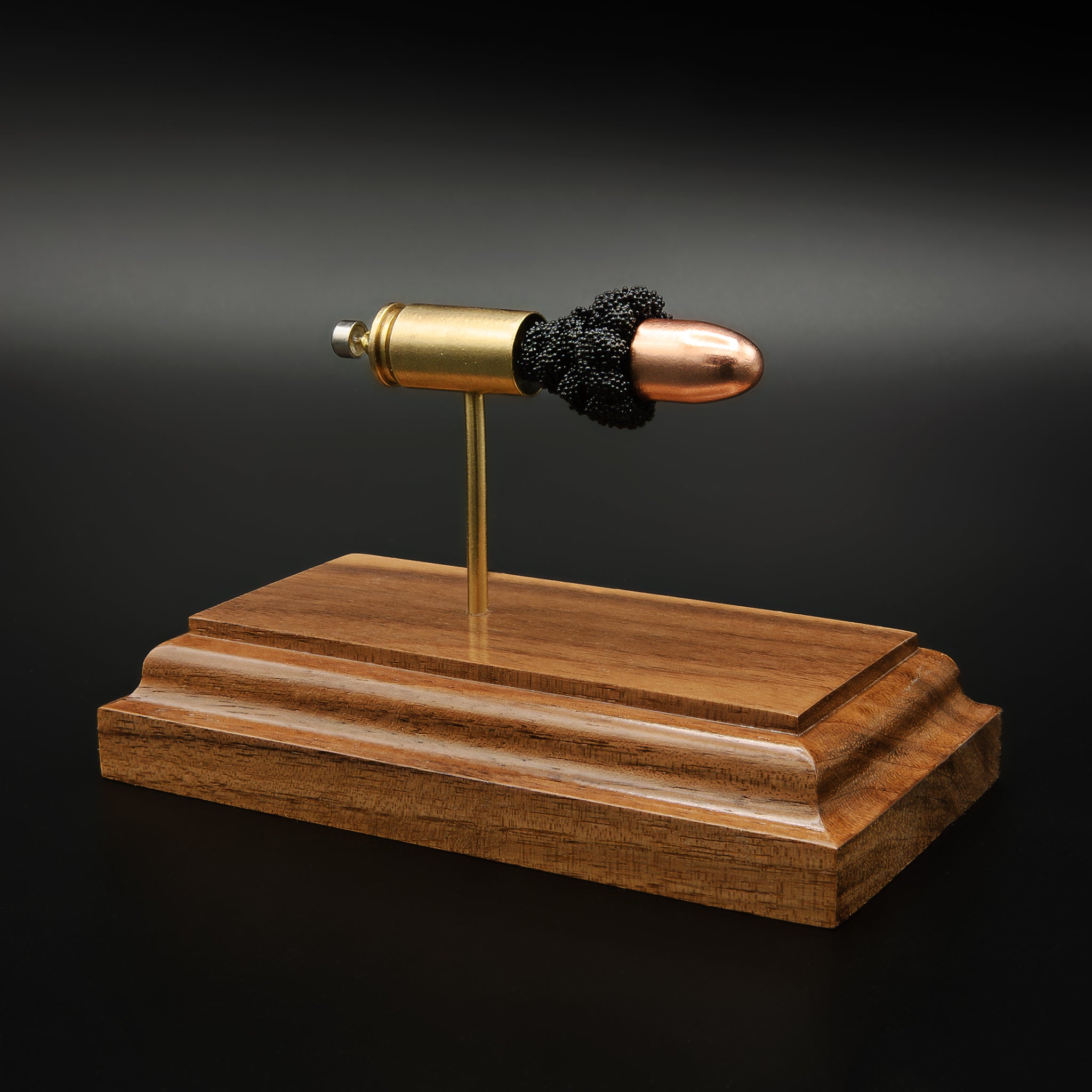 9mm Luger FMJ exploded cartridge anatomy model on walnut base
