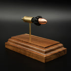Angled view of 9mm FMJ cartridge display with separated components on walnut base