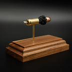 Rear view of 9mm cartridge display showing primer and case head on walnut base