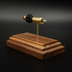 Back angled view of 9mm Luger FMJ exploded cartridge model on walnut base