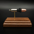 Side profile of 9mm Luger Speer Gold Dot 124gr cartridge anatomy model on walnut base