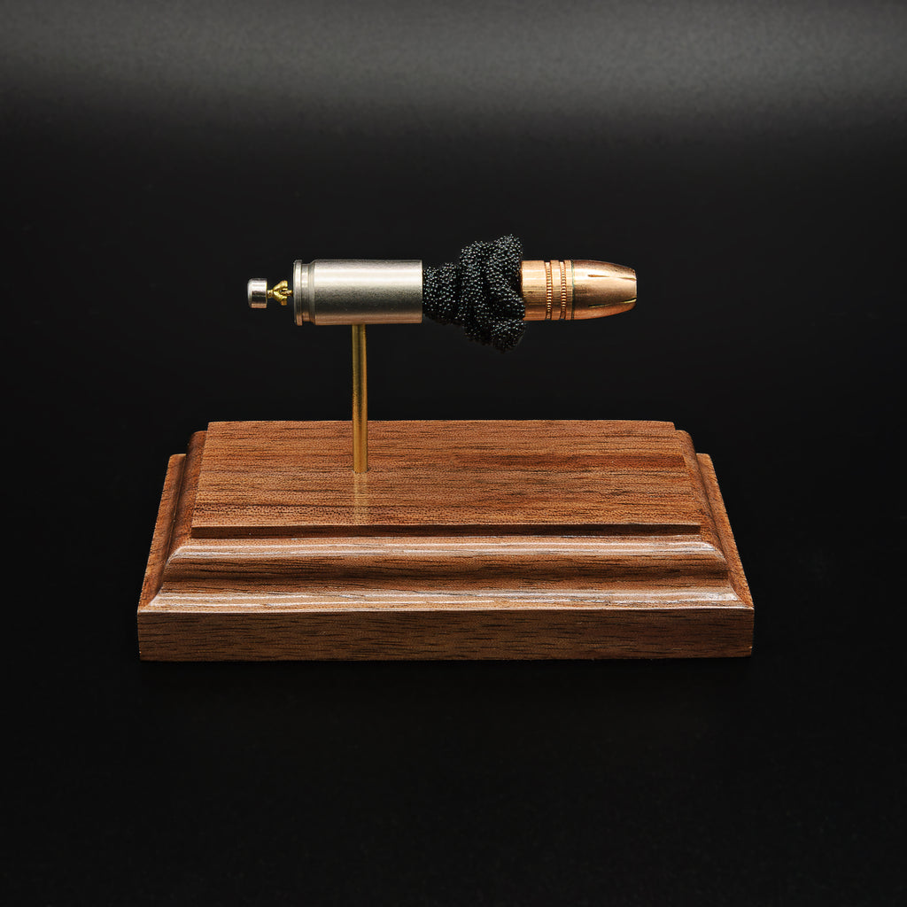 Front profile of a handcrafted 9mm Luger display showcasing the Federal 147gr HST hollow point bullet, nickel-plated case, exposed simulated powder, and walnut wood base.