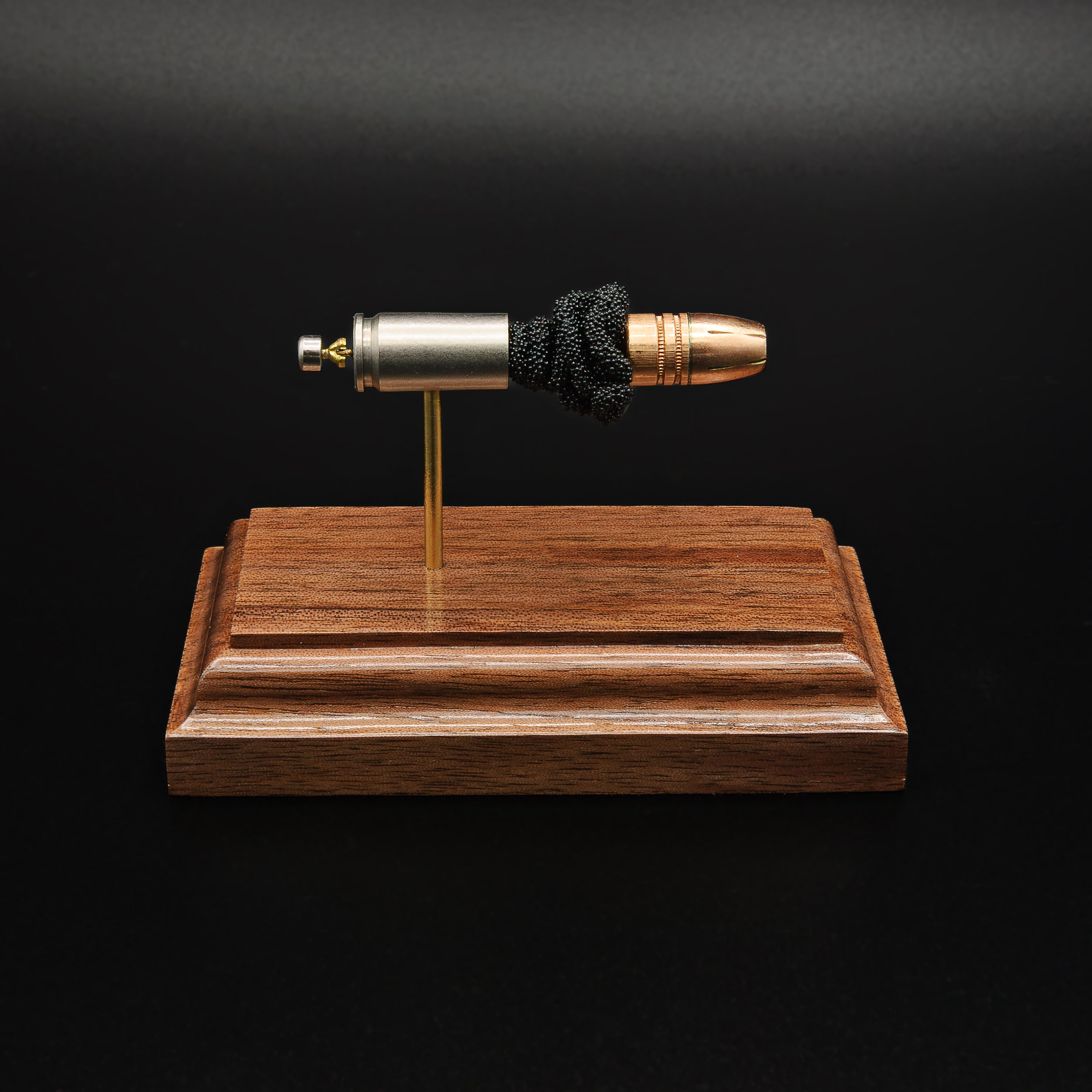 Front profile of a handcrafted 9mm Luger display showcasing the Federal 147gr HST hollow point bullet, nickel-plated case, exposed simulated powder, and walnut wood base.