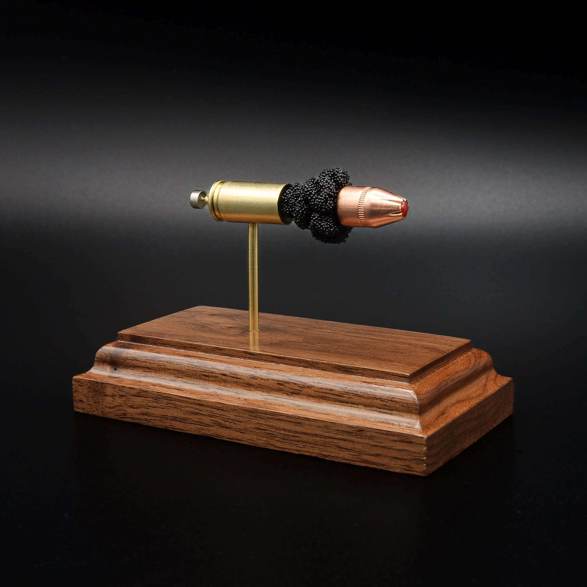 9mm Luger Hornady Critical Defense 115gr FTX exploded cartridge anatomy display on walnut base