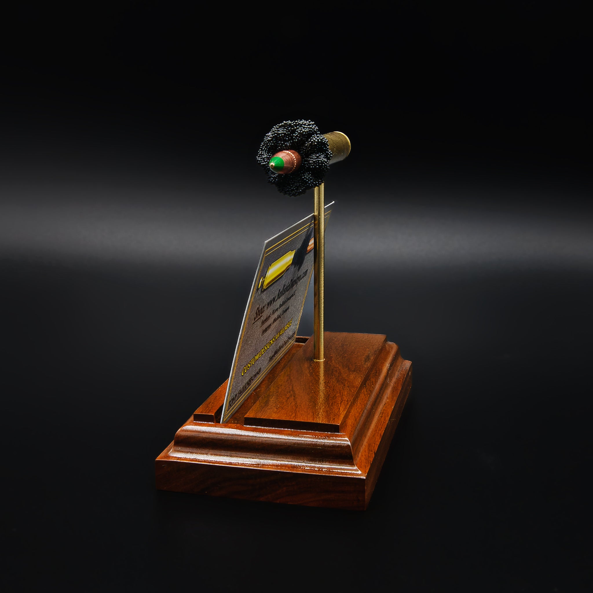 Angled view of ammunition-inspired desk accessory holding business cards, combining functional design with display appeal