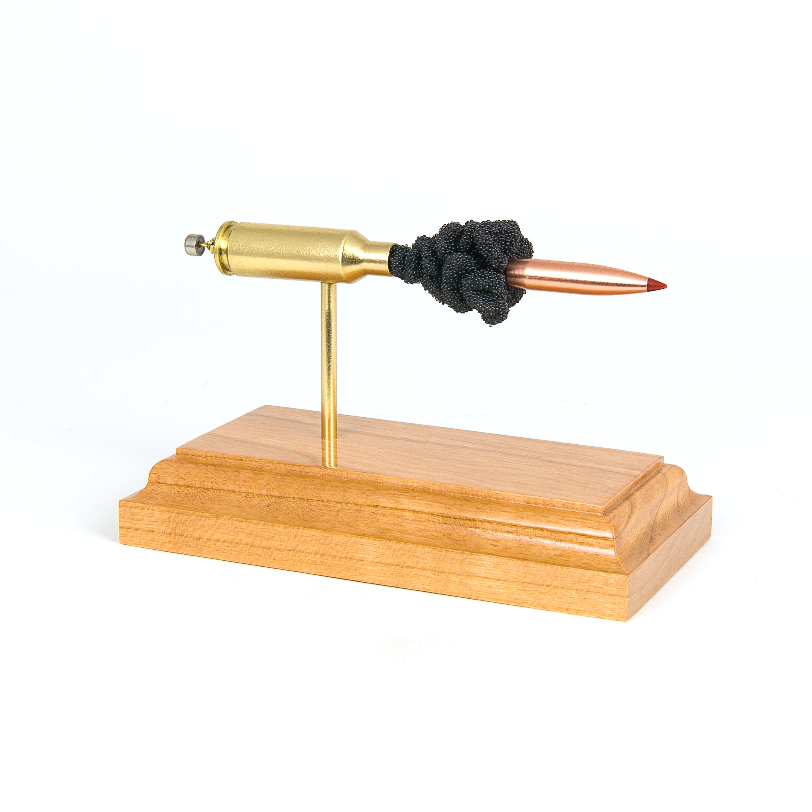 Expanded 6mm ARC ammunition cartridge model on hardwood base