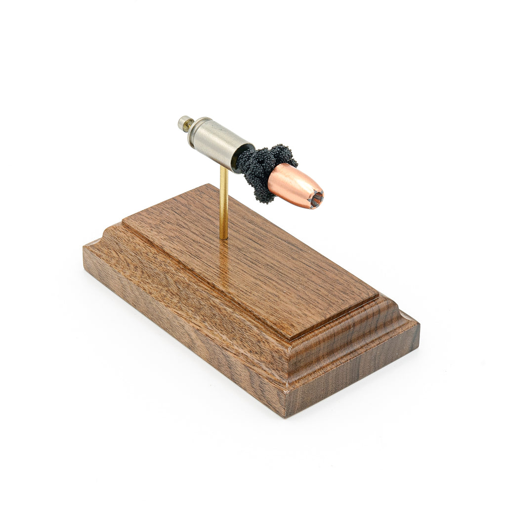 Angled view of 9mm Speer Gold Dot 124gr hollow point cartridge display on walnut base