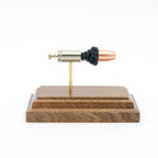 Side profile of 9mm Luger Speer Gold Dot 124gr cartridge anatomy model on walnut base