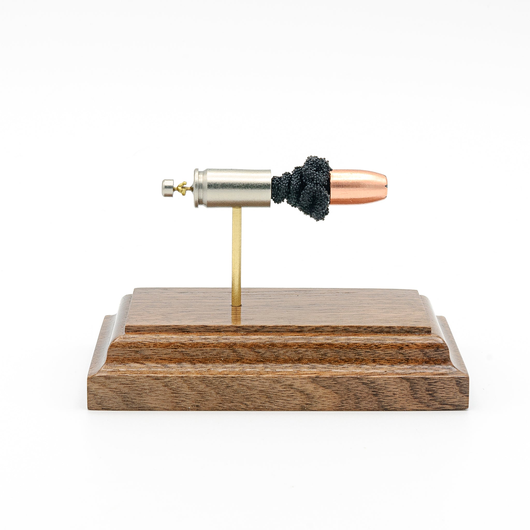 Side profile of 9mm Luger Speer Gold Dot 124gr cartridge anatomy model on walnut base