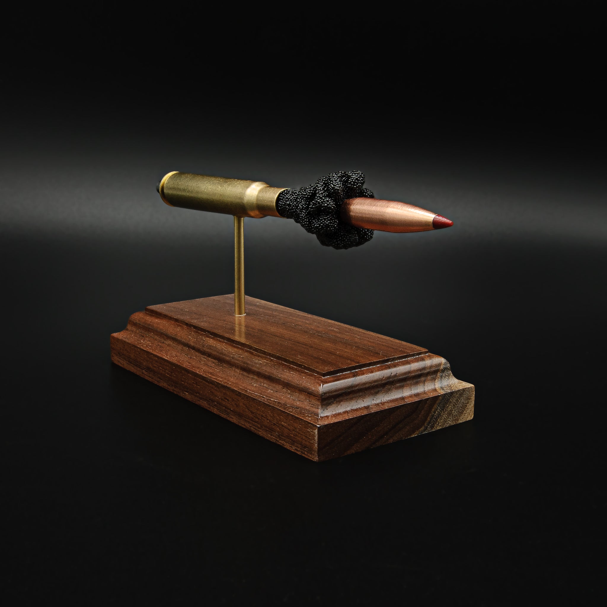 Close angled view of a .30-06 Springfield Hornady Precision Hunter 178gr ELD-X cartridge anatomy display highlighting the projectile, simulated powder, cartridge case, primer cup, and anvil on a hardwood base.
