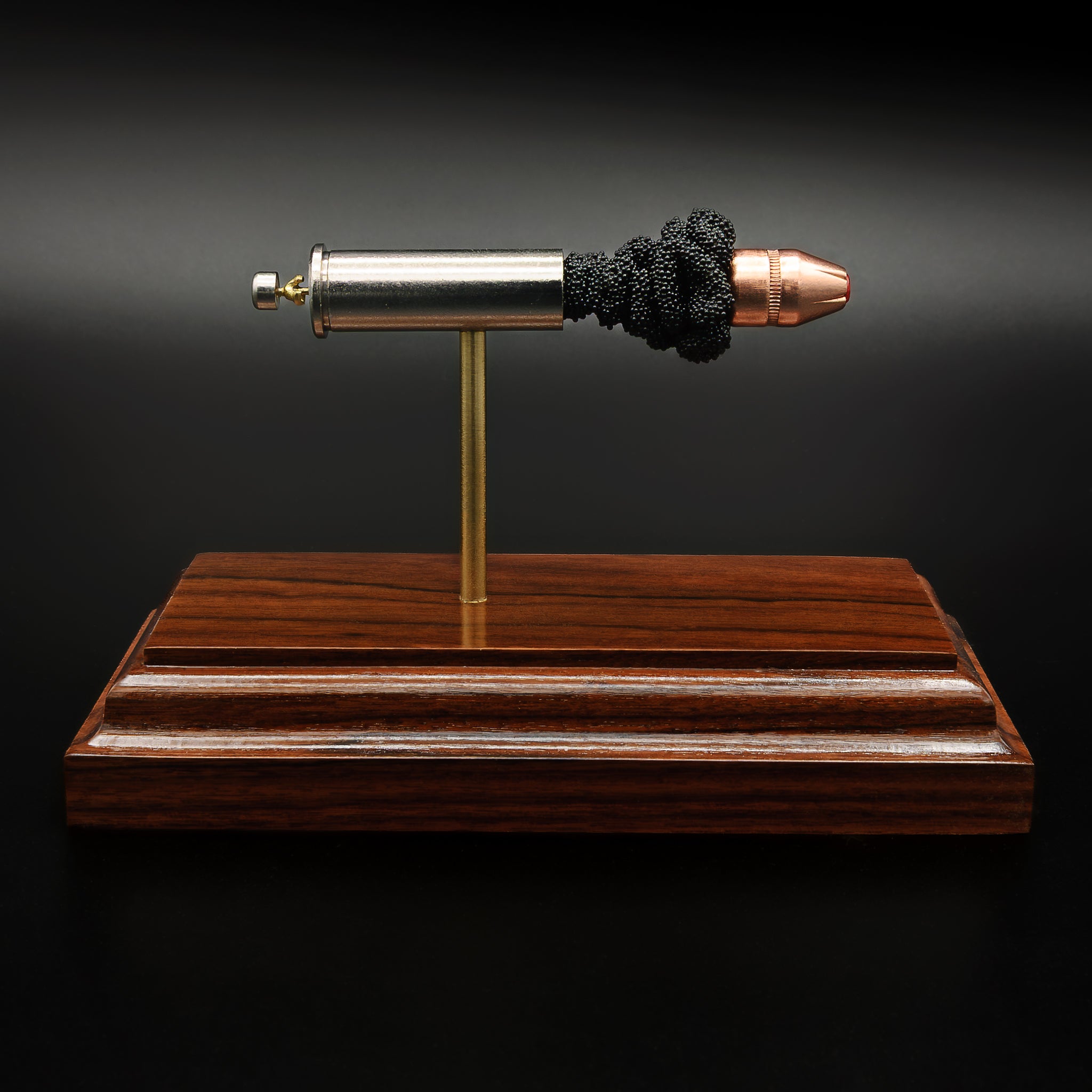 Side profile of .357 Magnum cartridge anatomy model featuring Critical Duty bullet on rosewood base