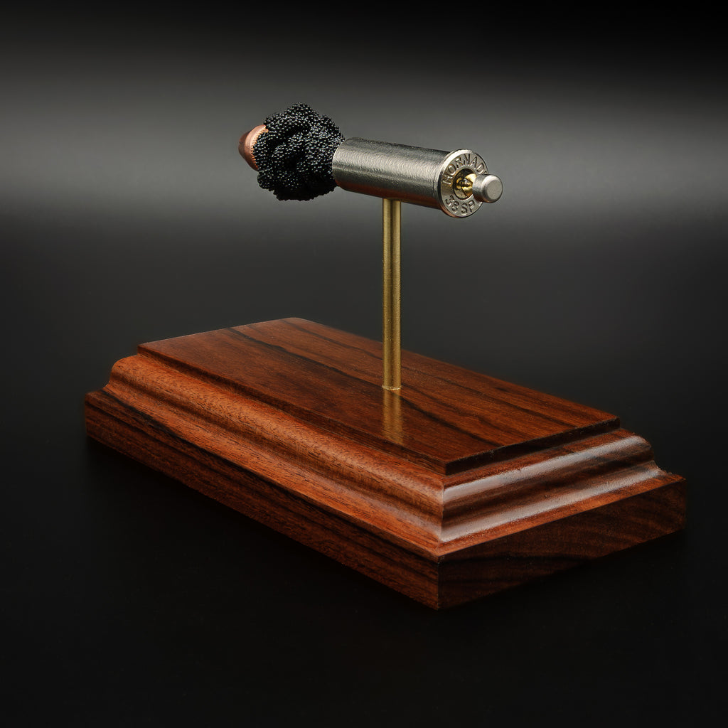 exploded handgun cartridge display showing bullet, powder, case and primer on Bolivian rosewood base