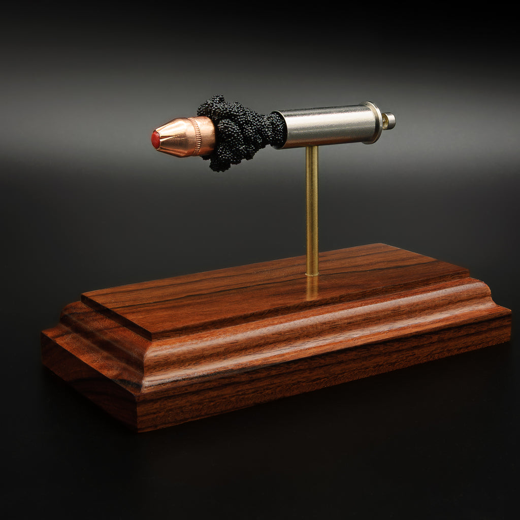ballistic cartridge component display model with Hornady FTX defensive bullet on hardwood stand