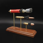 Angled view of a Heavy Metal 3-Gun display showing expanded 12 gauge, 308 Winchester and 45 Auto cartridges with their internal components visible.