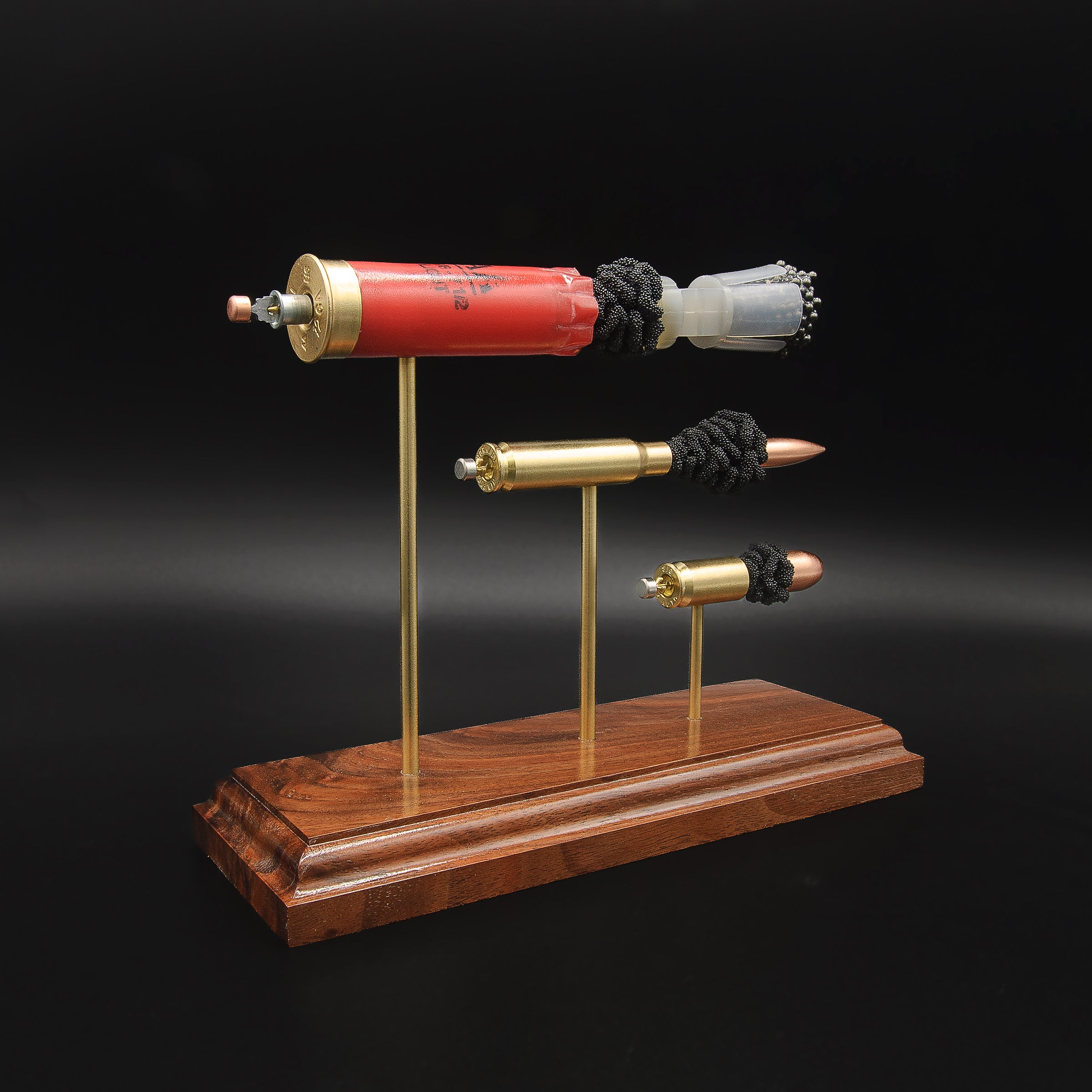 Rear angled view of the Heavy Metal 3-Gun display showing the primer cup, anvil, cartridge cases, simulated powder, wad, shot and projectiles.