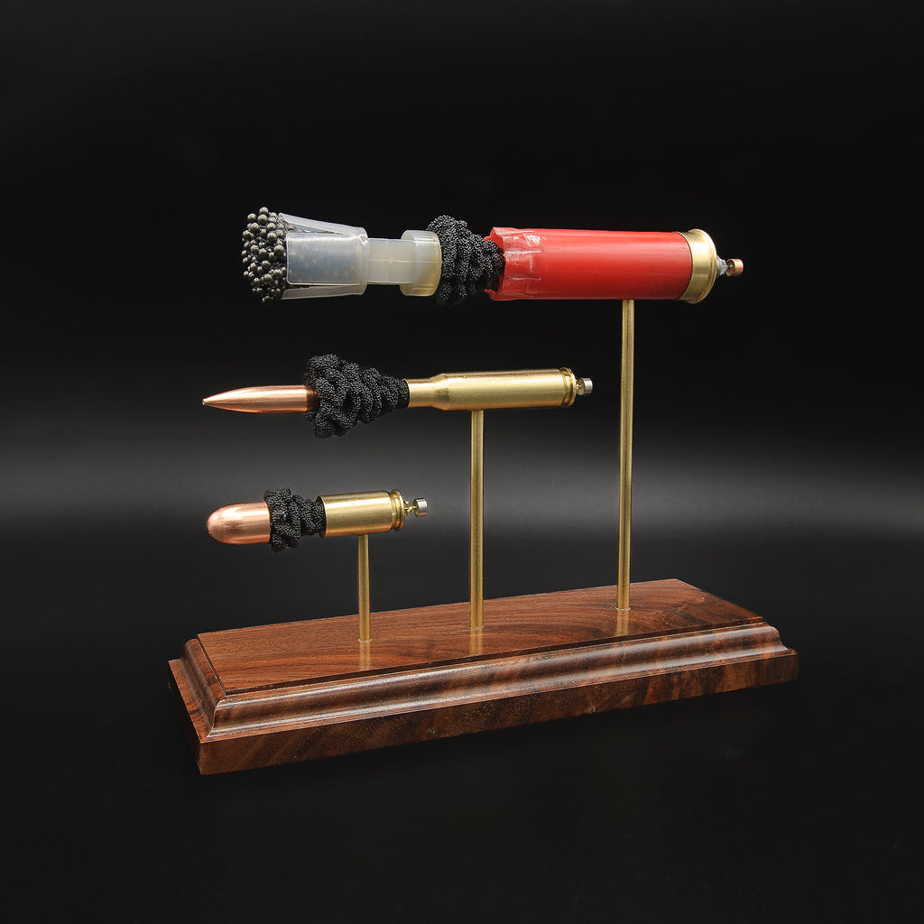 End view of the Heavy Metal 3-Gun cartridge display highlighting the 12 gauge shotshell base and the case heads of the 308 Winchester and 45 Auto.