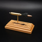 Angled view of a .223 Remington FMJ cartridge anatomy display highlighting the projectile, simulated powder, cartridge case, primer cup, and anvil on a cherry wood base with an engraved anatomy diagram.