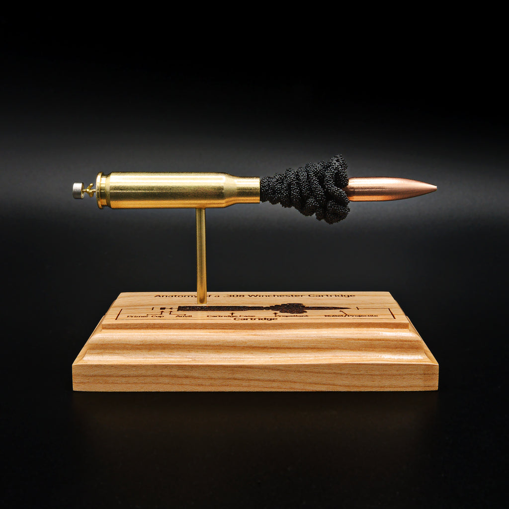 Front view of a handcrafted .308 Winchester cartridge anatomy display featuring a 168gr Sierra MatchKing HPBT bullet with an engraved anatomy diagram on a solid cherry wood base.