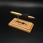 Overhead angle of a handcrafted .308 Winchester exploded cartridge display with a 168gr Sierra MatchKing HPBT bullet and detailed engraved anatomy diagram on a solid cherry wood base.