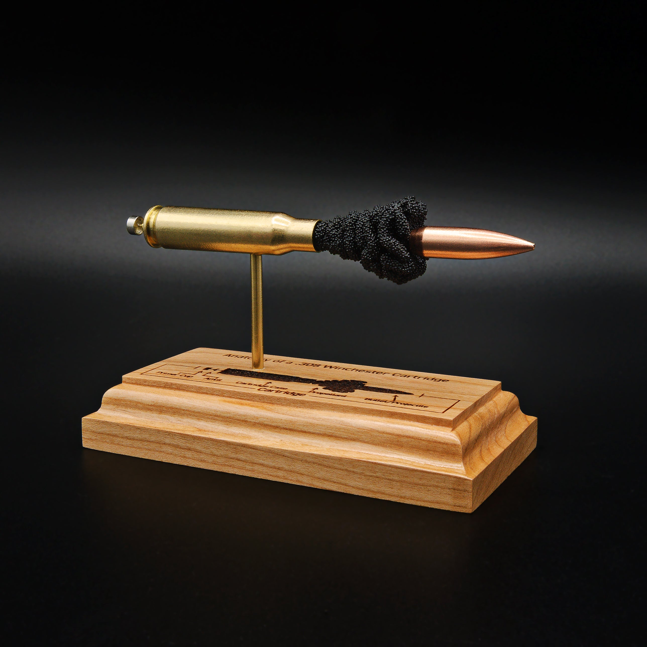 Front left angle of a .308 Winchester anatomy display showcasing a 168gr Sierra MatchKing HPBT bullet and engraved cartridge component diagram on a handcrafted cherry wood base.