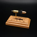 Front angled view of a handcrafted 9mm Luger cartridge anatomy display featuring a 115gr Sierra FMJ bullet with an engraved anatomy diagram showing the primer cup, anvil, cartridge case, powder, and projectile that is mounted on a solid cherry wood base.